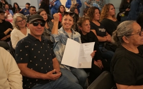 FOTO DE BENEFICIARIA MOSTRANDO SU TÍTULO DE DOMINIO